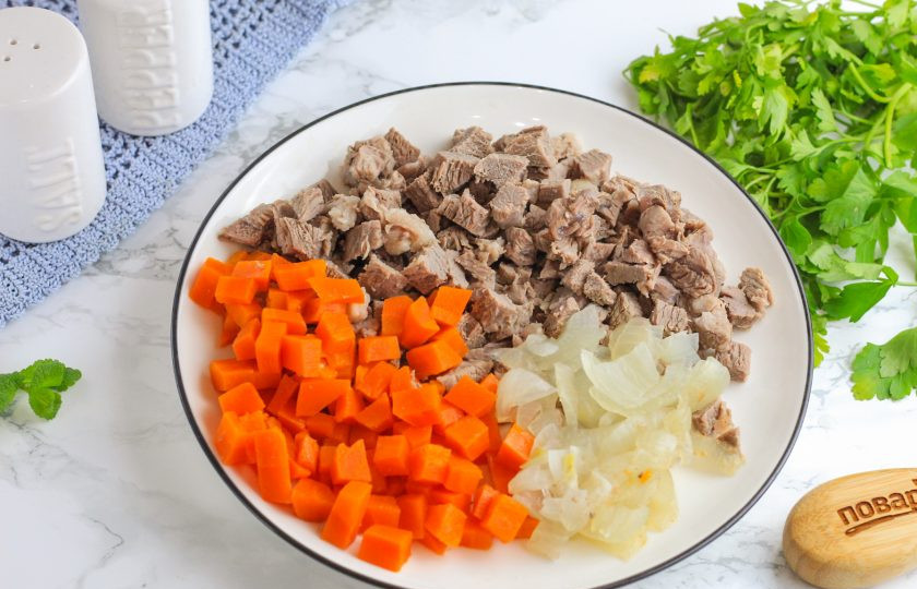 1. Этап. Заливное Провансаль из говядины: Извлеките мясо и овощи из бульона, а в бульон спрессуйте очищенные зубчики чеснока. Говядину и овощи нарежьте мелкими кубиками.