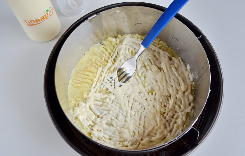 1. Этап. Селедочный чизкейк: 4. Картофель натрите на крупной терке. Распределите его по донышку, посолите. Майонез смешайте с пастоподобным сыром, смажьте картофельный слой.