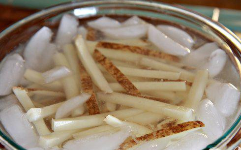 1. Этап. Хрустящий картофель-фри: 1. Промыть картофель в большой миске с большим количеством холодной проточной воды, пока вода не станет чистой. Нарезать картофель длинными полосками толщиной около 6 мм. Залить водой со льдом и накрыть крышкой. Поставить в холодильник по крайней мере на 30 минут или до 2 дней.