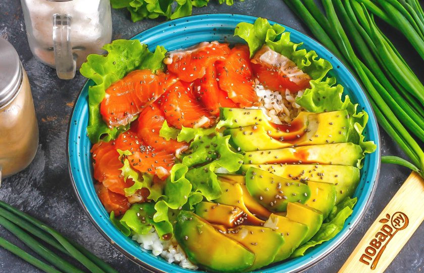 1. Этап. Боул с лососем и авокадо: Промойте листовой салат и оторвите стебли. Украсьте зеленью боул и присыпьте семенами чиа. Полейте оставшимся в пиале соевым соусом.