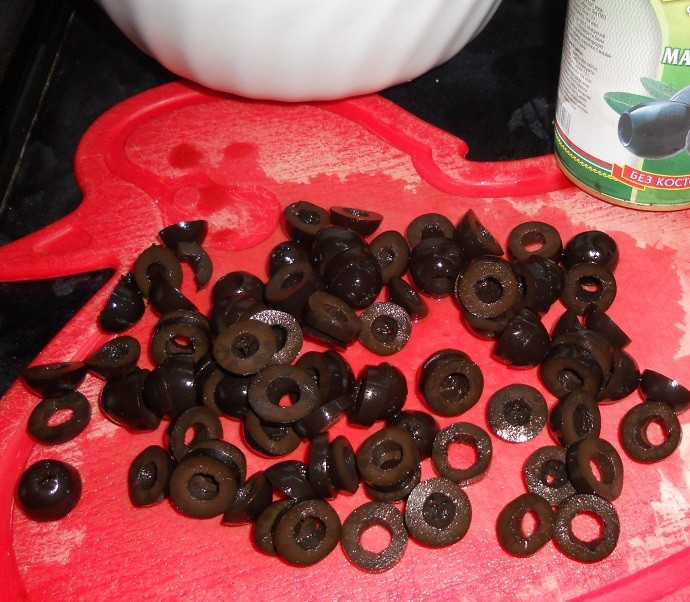 1. Этап. Салат из кальмаров и оливок: Оливки нужны без косточек. Нарежьте их колечками.