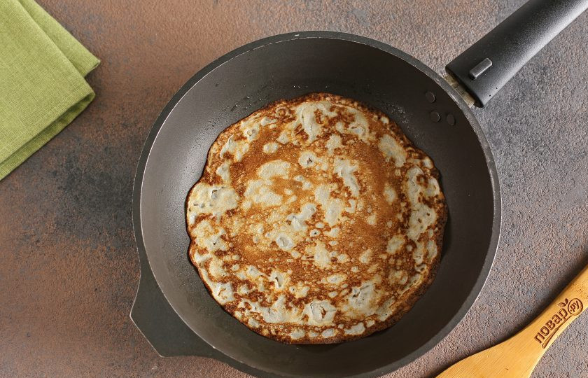 1. Этап. Блины с авокадо: Разогрейте сковороду и смажьте ее маслом. Налейте половину стандартного половника теста и распределите его равномерно по всей поверхности. Жарьте блинчики с двух сторон до готовности.