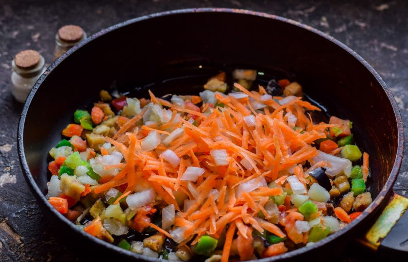 1. Этап. Булгур с фаршем: Морковь и лук очистите, сполосните и просушите. Нарежьте лук небольшими кубиками, морковь натрите на терке. Добавьте овощи в сковороду.