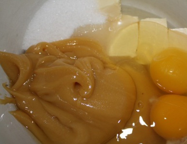 1. Этап. Медовый пирог с грецкими орехами: Смешайте в миске сливочное масло, 100 г. сахара, яйца, мед и соду. Поставьте на водяную баню на 5 минут и постоянно помешивайте до образования однородной массы. Затем добавьте муку, хорошо перемешайте и уберите на ночь в холодильник. Утром выньте из холодильника и дайте постоять еще часа три прежде чем использовать.