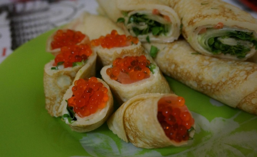 1. Этап. Блинные роллы со сливочным сыром и красной рыбой: Нарежьте блины порционно, роллами, украсив их икрой. Приятного аппетита!