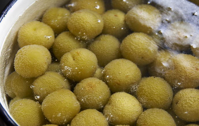 1. Этап. Ткемали из алычи: Зеленую алычу моем, заливаем водой и варим до готовности.