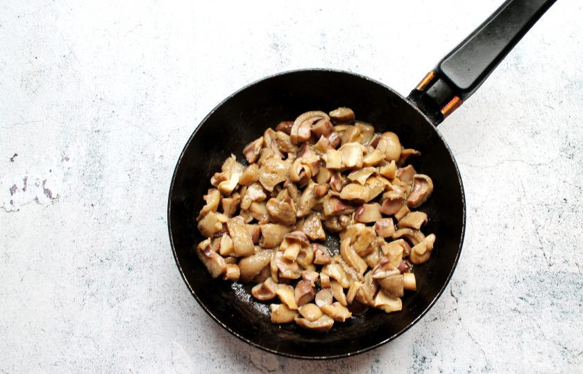 1. Этап. Жульен из маслят: Грибы сполосните и порежьте дольками. В сковороду налейте растительное масло и разогрейте, добавьте грибы. Обжаривайте их в течение 10 минут, до выпаривания жидкости. Переложите грибы в тарелку.