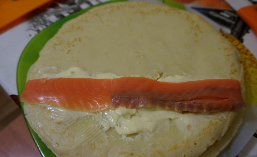 1. Этап. Блинные роллы со сливочным сыром и красной рыбой: Любую красную рыбу нарежьте полосками. Уложите их на сыр.