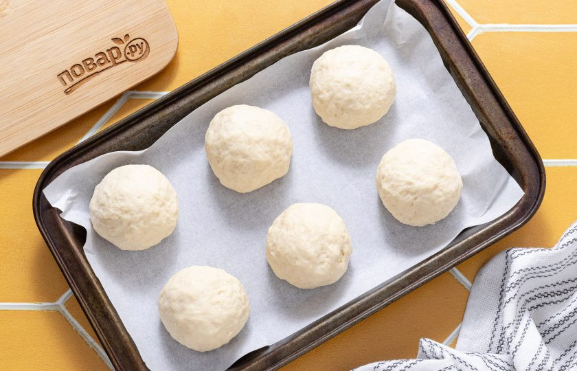 1. Этап. Булочки без яиц на йогурте: Сформируйте из теста булочки и выложите на пергамент для выпечки. Выпекайте булочки в разогретой до 210-220 градусов духовке 15-20 минут. За 5 минут до готовности смажьте их маслом и посыпьте кунжутом.