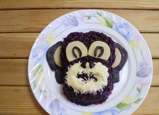 1. Этап. Селедка под шубой в виде обезьянки: Из тертого на мелкой терке сыра сделайте рот. Сделайте обезьянке носик.