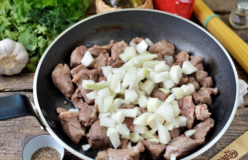 1. Этап. Вкусный лагман: Порежьте кубиком репчатый лук, переложите в сковороду, перемешайте.