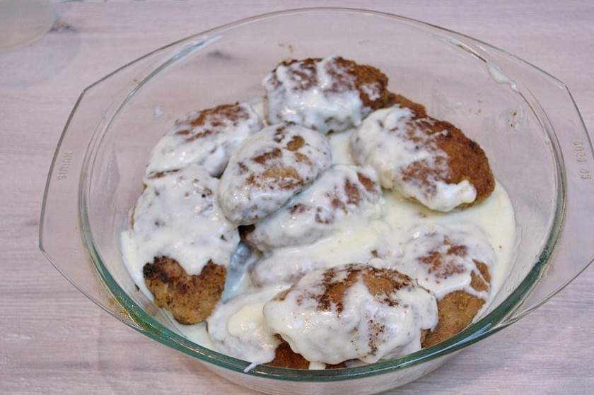 1. Этап. Котлеты под соусом Бешамель: Обжаренные котлеты уложите в емкость. Залейте подготовленным соусом 