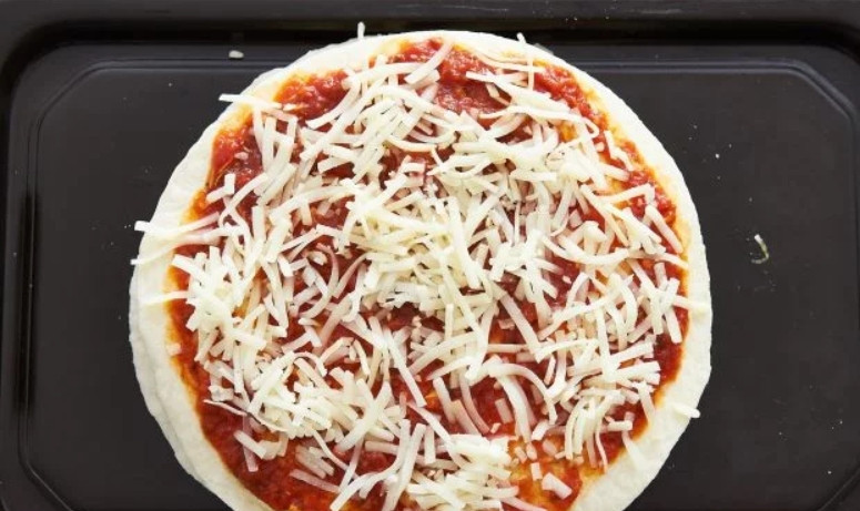 1. Этап. Пиццадилья: 5. Накройте еще одной тортильей и смажьте ее соусом, добавьте чуть сыра.