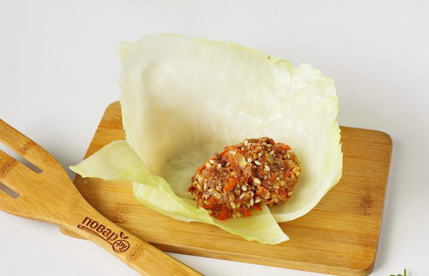 1. Этап. Голубцы по-румынски: Срежьте у капустного листа толстую прожилку и выложите посередине немного фарша.