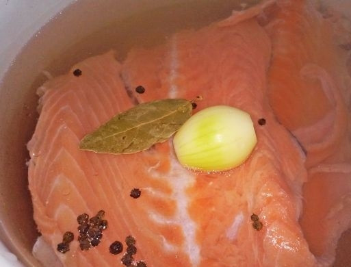 1. Этап. Лососевый суп: 3. Заливаю кастрюлю с хребтом холодной водой, добавляю черный перец горошком, лавровый лист (1 штука) и очищенный лук. Отправляю кастрюлю на огонь и варю после закипания на слабом огне полчаса.