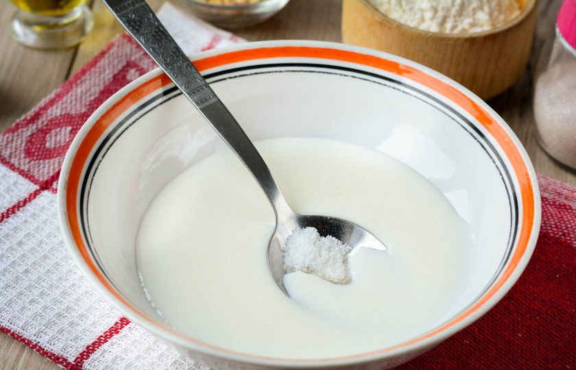 1. Этап. Тонкие пирожки на кефире: Влейте кефир в миску, смешайте с солью и сахаром.