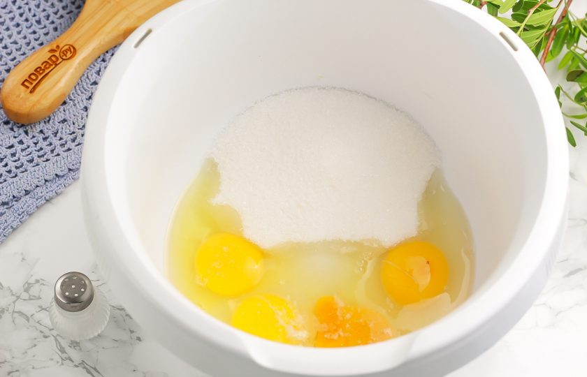 1. Этап. Торт Змейка на Новый год: Куриные яйца вбейте в чашу кухонного комбайна или миксера, всыпьте соль, сахар и взбейте в течение 3-4 минут в пышную пену на самой высокой скорости техники.