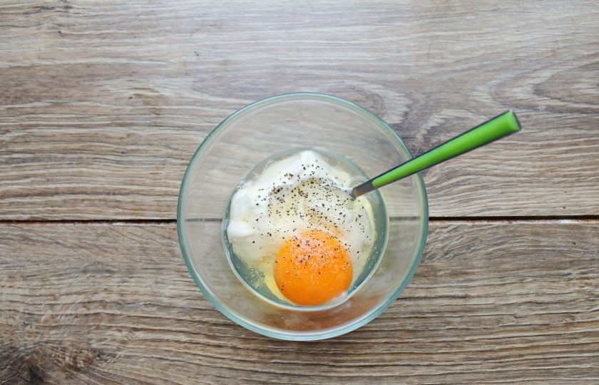 1. Этап. Картофель с беконом в сметанной заливке: В миске смешайте сметану, яйцо, посолите и поперчите. Все перемешайте вилкой до однородности.