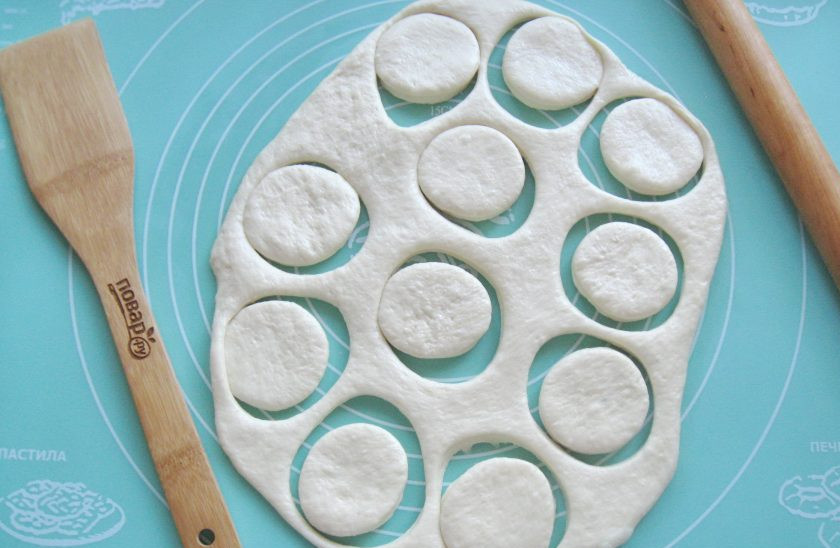 1. Этап. Пончики Бомболони: Тесто достаньте из миски, обомните и раскатайте в пласт толщиной 1 см. С помощью стакана сделайте круги диаметром 6-7 см.