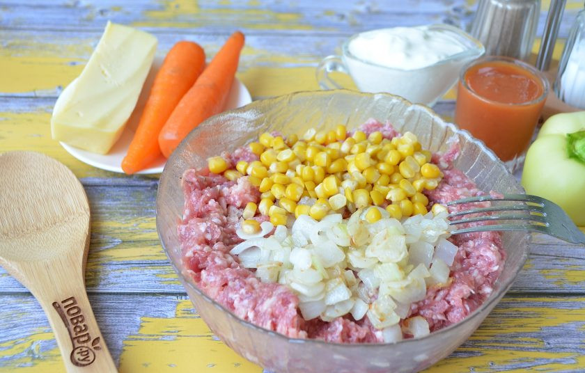 1. Этап. Мясные буханки с сюрпризом: 4. Порежьте кубиками луковицу, обжарьте на чайной ложке растительного масла и добавьте к фаршу, положите кукурузу. Перемешайте.