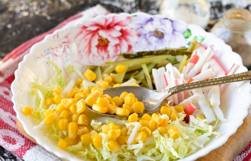1. Этап. Крабовый салат с соленым огурцом: Добавьте в салат консервированную кукурузу.