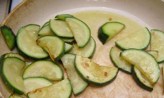 1. Этап. Салат с цукини: 3. Разогрейте на сковородке растительное масло. Выкладывайте нарезанный цукини порциями. Жарьте на среднем огне, постоянно переворачивайте для равномерной обжарки.