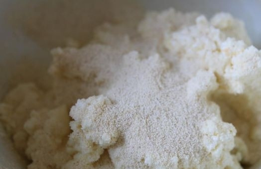 1. Этап. Пирог из моркови и творога: 5. Всыпьте немного манной крупы и все как следует перемешайте. Творожную массу разделите на две части, чтобы сделать пирог в два слоя с разными начинками.