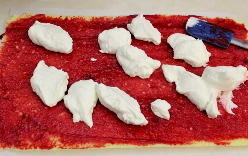 1. Этап. Рулет бисквитный с ягодами: 13. Остывший бисквит смажьте ягодной начинкой. Затем, поверх ягод, нанесите сливочный слой.