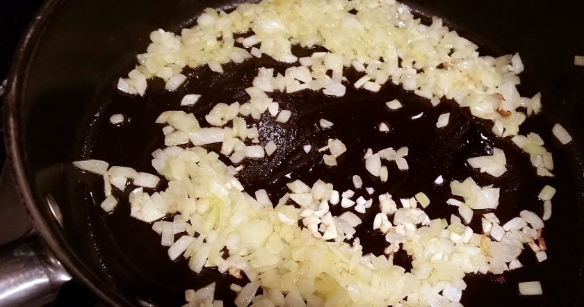 1. Этап. Мясо с макаронами: Лук измельчаем, чеснок давим через пресс и пассеруем их на растительном масле до прозрачного цвета.