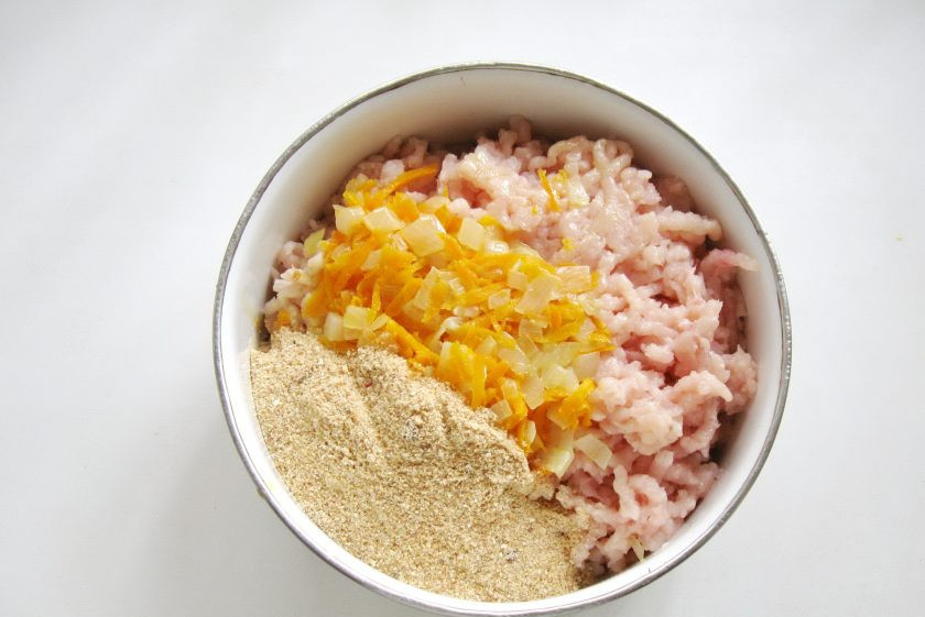 1. Этап. Кабачки фаршированные курицей в мультиварке: Половину тушеных овощей(моркови с луком) выложите в миску с куриным фаршем. Добавьте панировочные сухари.