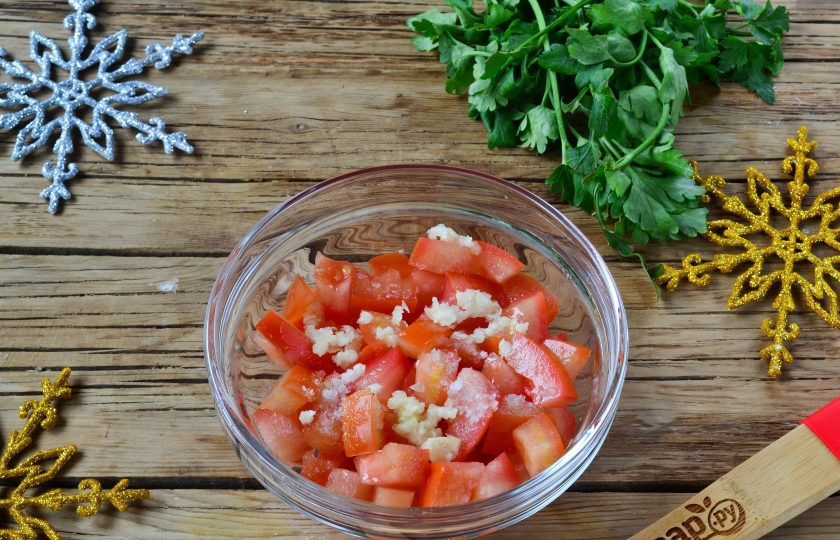 1. Этап. Салат Коррида с крабовыми палочками: Каждый помидор промойте под проточной водой. Разрежьте помидоры пополам и в каждой четвертушке удалите мякоть, благодаря чему наш салат не потечет. Порежьте мясистую часть помидоров на кусочки, добавьте пропущенный через пресс чеснок и соль, перемешайте.