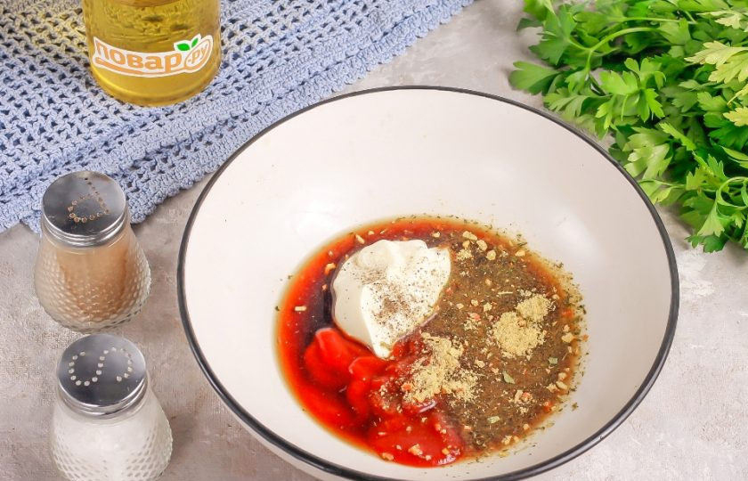 1. Этап. Куриные Чупа-чупсы: В глубокой емкости соедините кетчуп чили, майонез, соевый соус, приправу для курицы, соль и молотый черный перец. Если блюдо будут есть и дети, то замените кетчуп чили на более нежный. Аккуратно все перемешайте.