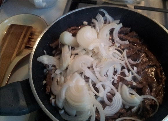 1. Этап. Говядина по-японски: В некоторых вариантах этого рецепта говядину замачивают на 1 день в минералке, но я этого не делаю, и получается тоже вкусно. Итак, теперь мясо нарезано, и мы разогреваем на сковороде масло. Обжариваем на нем говядину, пока из него немного не выпариться жидкость. Затем добавляем лук.