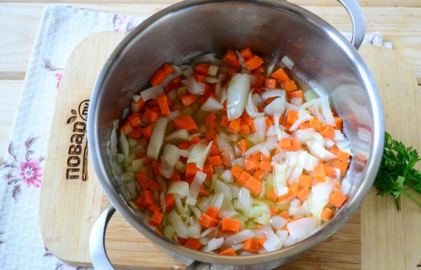 1. Этап. Тыквенный суп с сыром: В кастрюльке, в которой будете варить супчик, разогрейте растительное масло, отправьте туда порезанный мелко лук и жарьте до мягкости. Затем добавьте натертую на крупной терке морковь и измельченный чеснок, готовьте несколько минут.