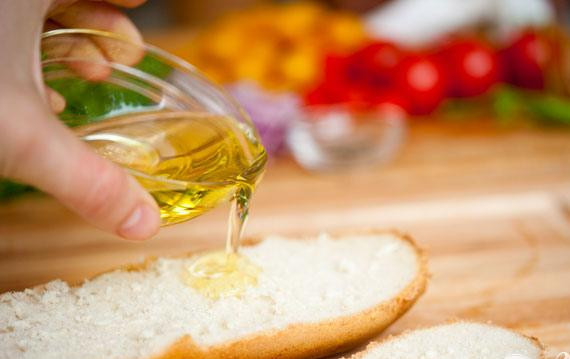 1. Этап. Салат с хлебом и помидорами: 3. Разогреть духовку до 160 градусов. Разрезать багет вдоль пополам и смазать две половинки со всех сторон оливковым маслом. Затем натереть багет со всех сторон чесноком.