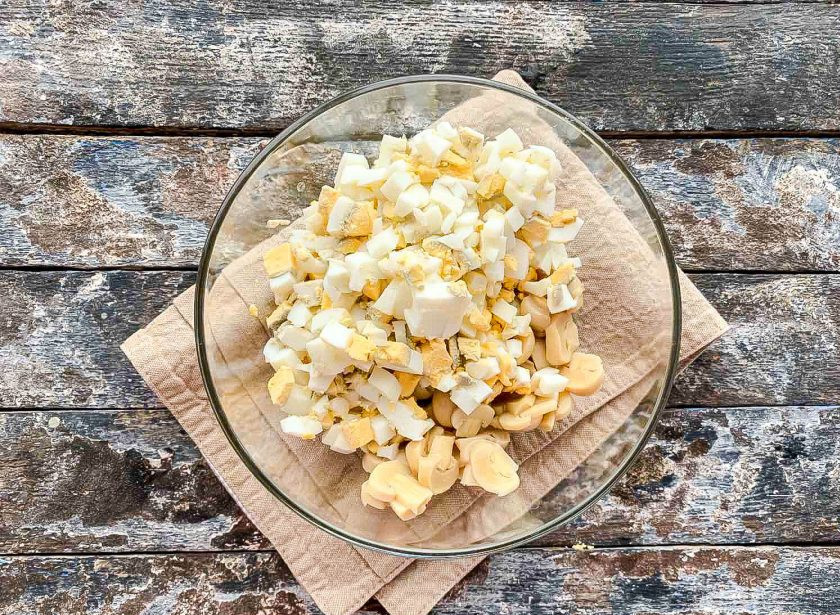 1. Этап. Салат из шампиньонов маринованных: Яйца очистите от скорлупы, мелко нарежьте и добавьте к грибам.