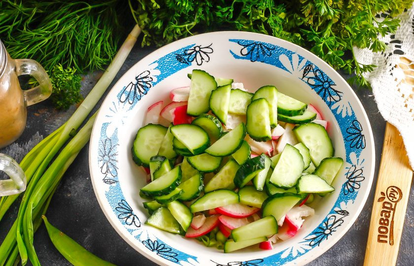 1. Этап. Салат с тыквенным маслом: Промойте свежий огурец и срежьте хвостики, нарежьте полукольцами, так же, как и редис. Добавьте в емкость к остальным нарезкам.