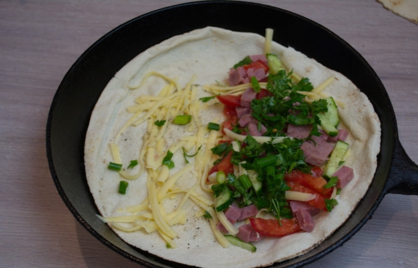 1. Этап. Кесадилья классическая: На одну сторону питы выложите нарезанные овощи, ветчину и зелень. По щепотке каждого продукта. Посолите, поперчите.