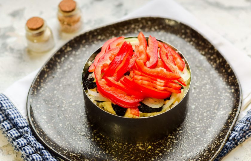 1. Этап. Салат Зимняя ночь: Сладкий перец нарежьте небольшими полосками и выложите поверх салата - это будет завершающий слой.