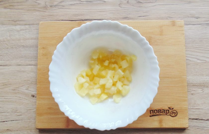 1. Этап. Салат из ананасов с чесноком и сыром: Ананас достаньте из банки и нарежьте мелко, по своему усмотрению. Выложите в салатник.