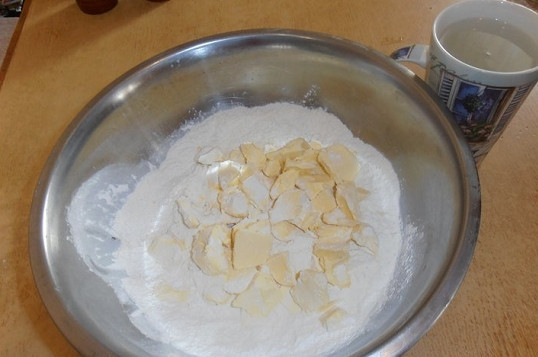 1. Этап. Кубете (пирог с мясом и картофелем): 1. Чтобы приготовить тесто, просейте в глубокую мисочку муку с солью. Туда же отправьте нарезанный кубиками маргарин. Аккуратно перемешайте. Влейте холодную воду.