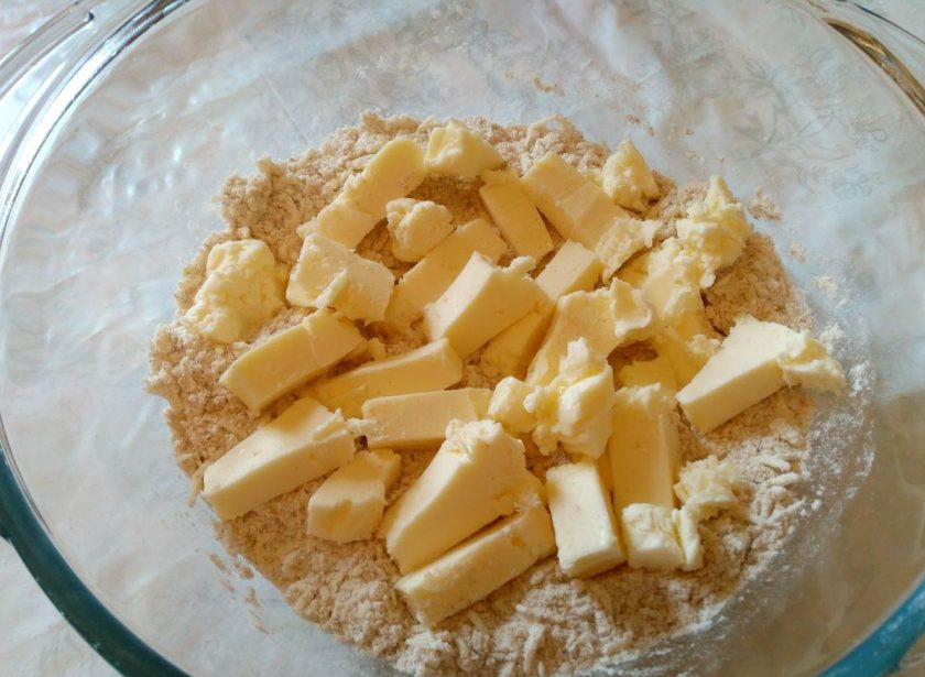 1. Этап. Квише с овощной начинкой: Сливочное масло нарежьте кубиками и добавьте в миску. Разотрите смесь руками до получения крошки.