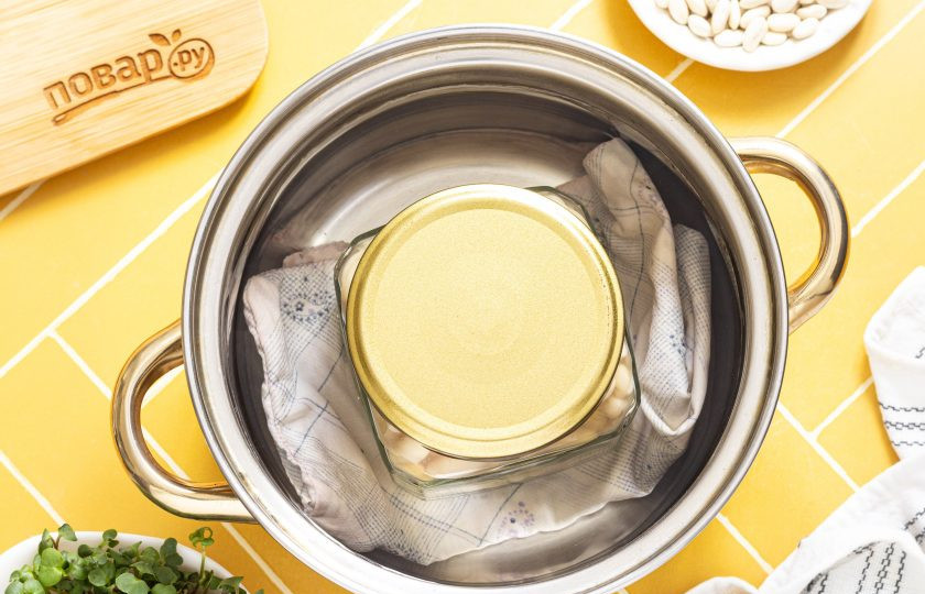 1. Этап. Фасоль белая консервированная: В кастрюлю постелите тряпочку или полотенце, поставьте банку и влейте воду по плечики банки. Стерилизуйте в кипящей воде 15 минут на умеренном огне.