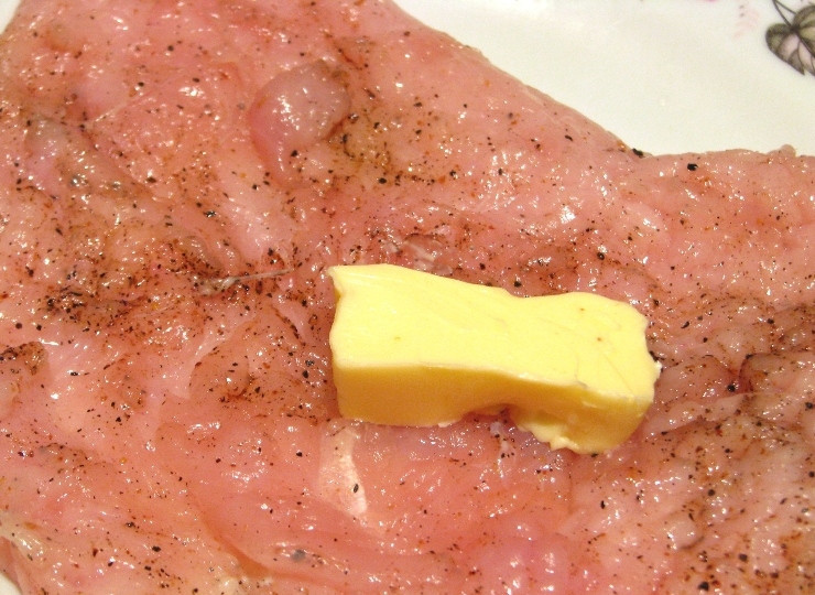 1. Этап. Курица по-столичному: Сливочное масло разрезаем на две равные части и кладем по кусочку в середину каждого филе.