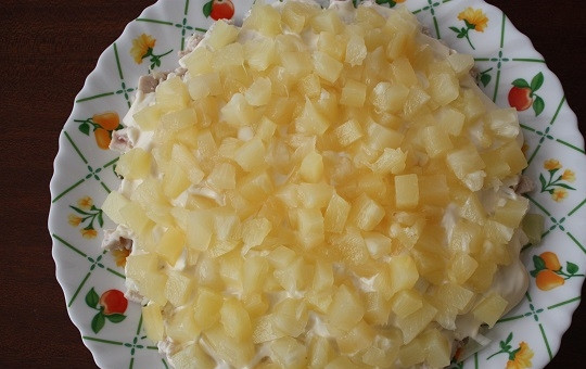 1. Этап. Салат с куриным филе и ананасами: 4. Нарежьте ананас кубиками (если он у вас изначально кольцами), распределите его ровным слоем.