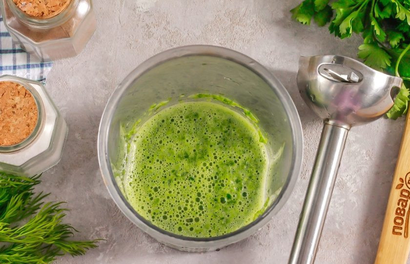 1. Этап. Блинчики шпинатные: Разберите в руках пучок шпината, срезав стебли. Промойте каждый лист в воде с обеих сторон и нарежьте их лентами. Выложите в стакан для погружного блендера или в чашу блендера и влейте воду. Измельчите все примерно 2-3 минуты, чтобы у вас получился зеленый смузи.