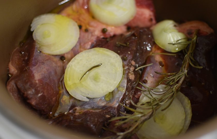 1. Этап. Говядина, томленная в оливковом масле: Налейте в чашу мультиварки немного больше половины стакана оливкового масла, уложите мясо. Сверху выложите луковицу, нарезанную толстыми кольцами, посыпьте мясо перцем и положите веточку розмарина. Полейте мясо сверху остатками масла. Не солите.