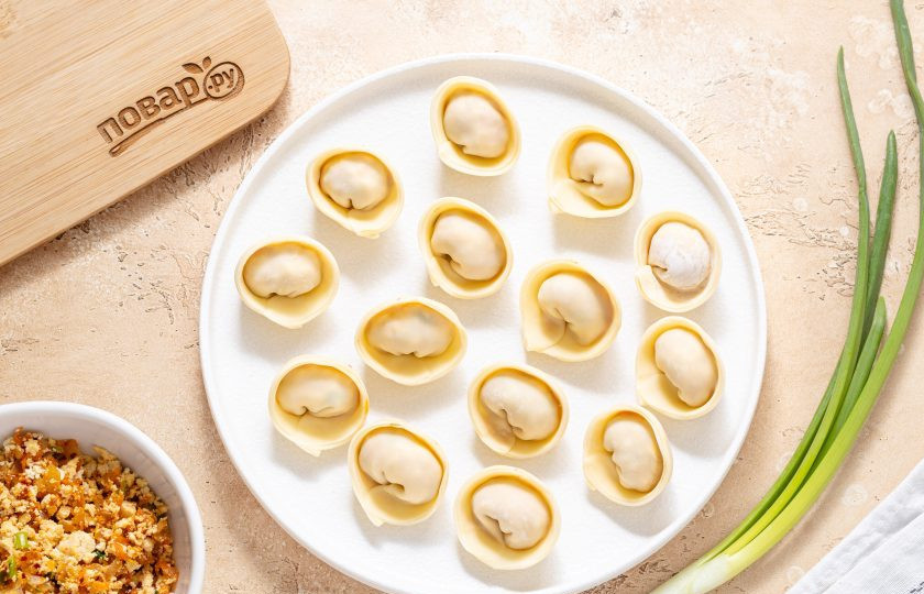 1. Этап. Пельмени с тофу и кимчи: Смажьте края водой, сложите пополам и защипните. Соедините два его острых конца внахлест. Повторите, пока не закончится тесто и начинка.