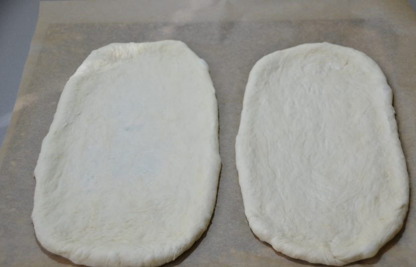 1. Этап. Пицца по-немецки: Обе заготовки теста для пиццы уложите на лист для выпечки.