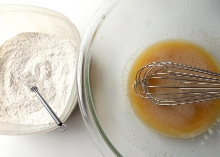 1. Этап. Печенье Бантики: Одно яйцо разделите на белок и желток (белок понадобится чуть позже, а желток можете по своему усмотрению использовать для приготовления другого блюда). Взбейте два полных яйца с водой, добавьте ванильный экстракт и остывшее масло сливочное, перемешайте хорошенько.